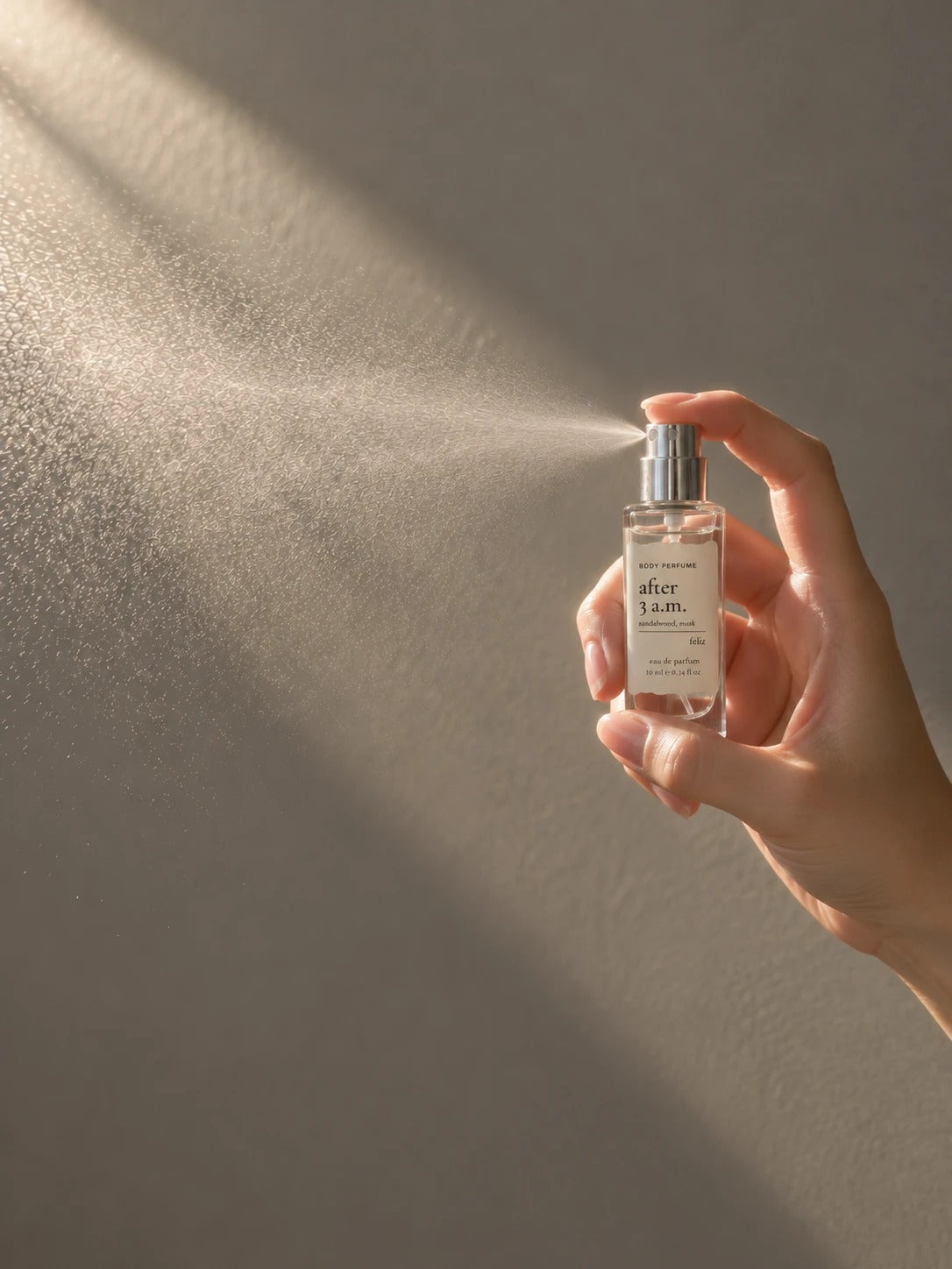 03 after 3 a.m. 10ml body perfume being sprayed, with fine mist visible