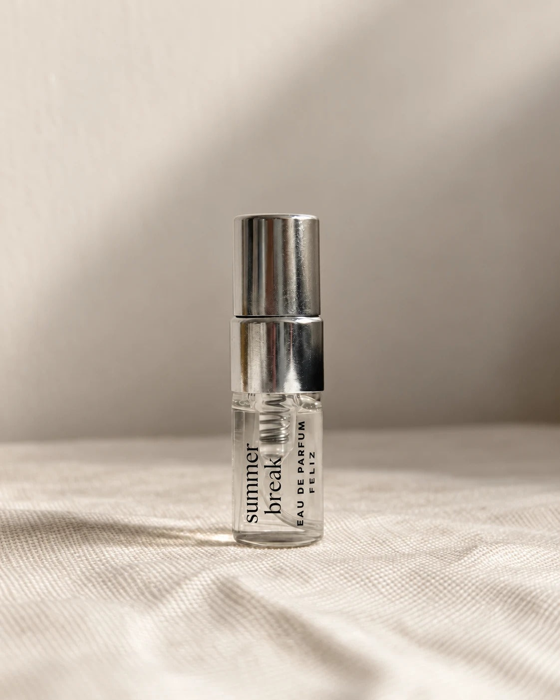 04 Summer Break body perfume, 2ml sample bottle on warm linen