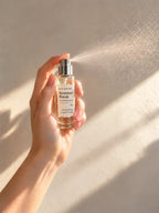 04 Summer Break 10ml body perfume being sprayed, with fine mist visible