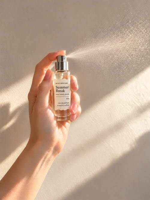 04 Summer Break 10ml body perfume being sprayed, with fine mist visible