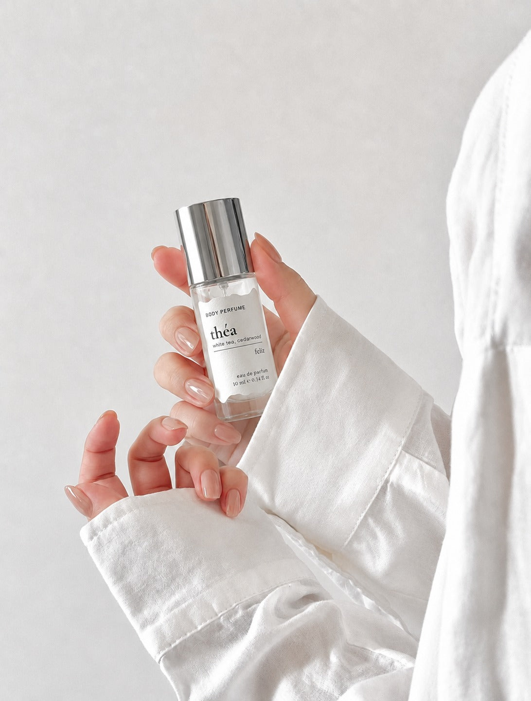 01 théa 10ml body perfume held in a hand