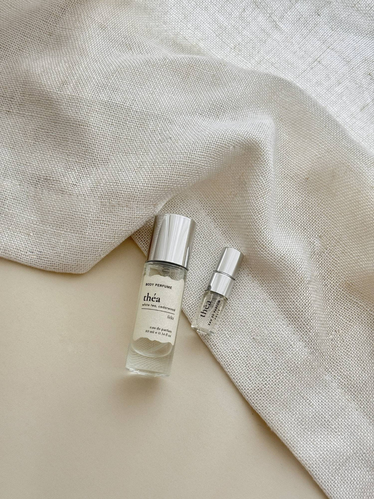 01 théa 10ml and 2ml perfume bottles together on cream linen