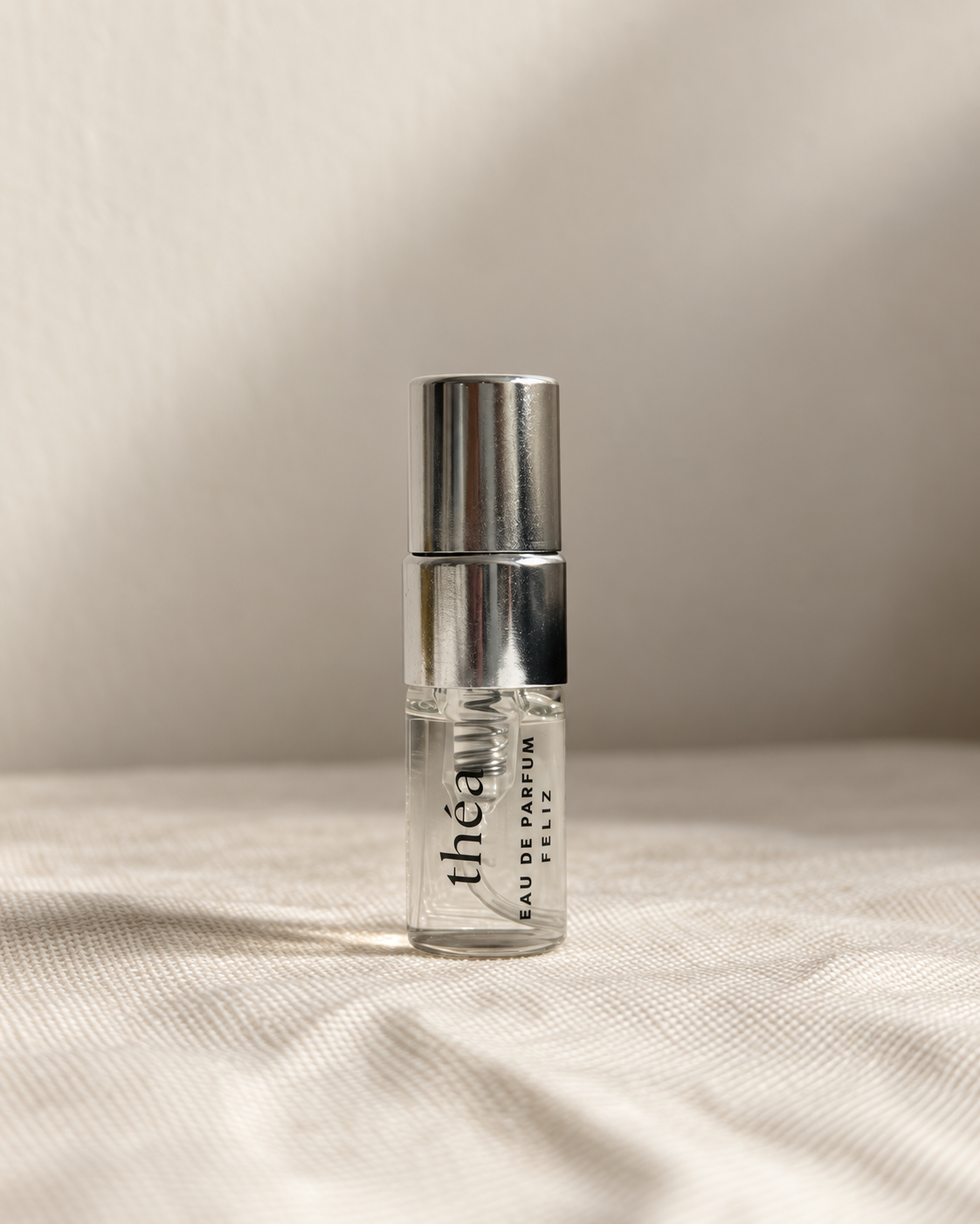 01 théa body perfume, 2ml sample bottle on warm linen
